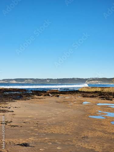 Waves crashing on the rock platform at Susan Gilmore Beach Newcastle New South Wales Australia. Taken at low tide
