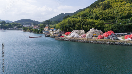Foto Aerial view of a coastal storage yard with fishing buoys and aquaculture equipment located beside the sea