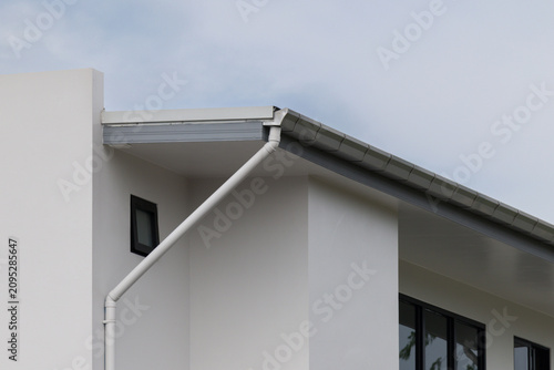 Modern home features sleek white gutters against plain white walls