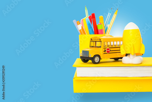 Colorful supplies and a yellow bus signify the start of school