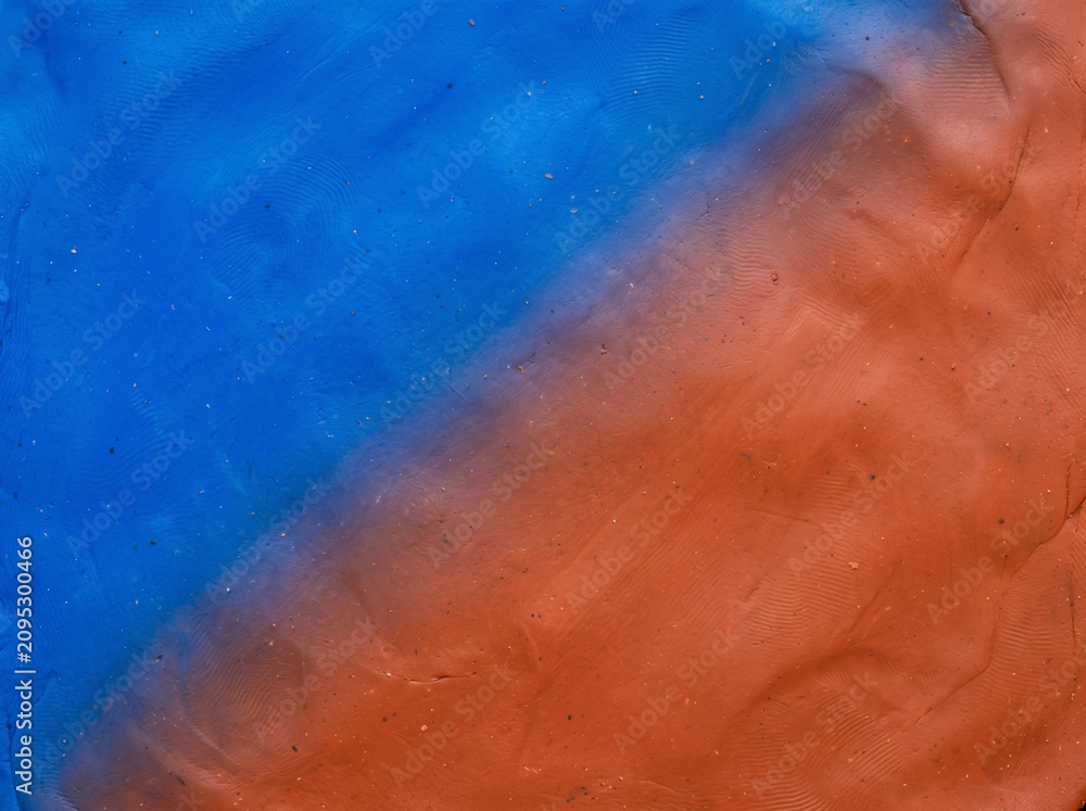 Fototapeta premium Textured Blue and Terracotta Orange Plasticine Clay Diagonal Background