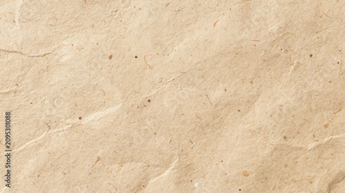 Close-up image of a textured beige stone surface with natural veins and small scattered inclusions.