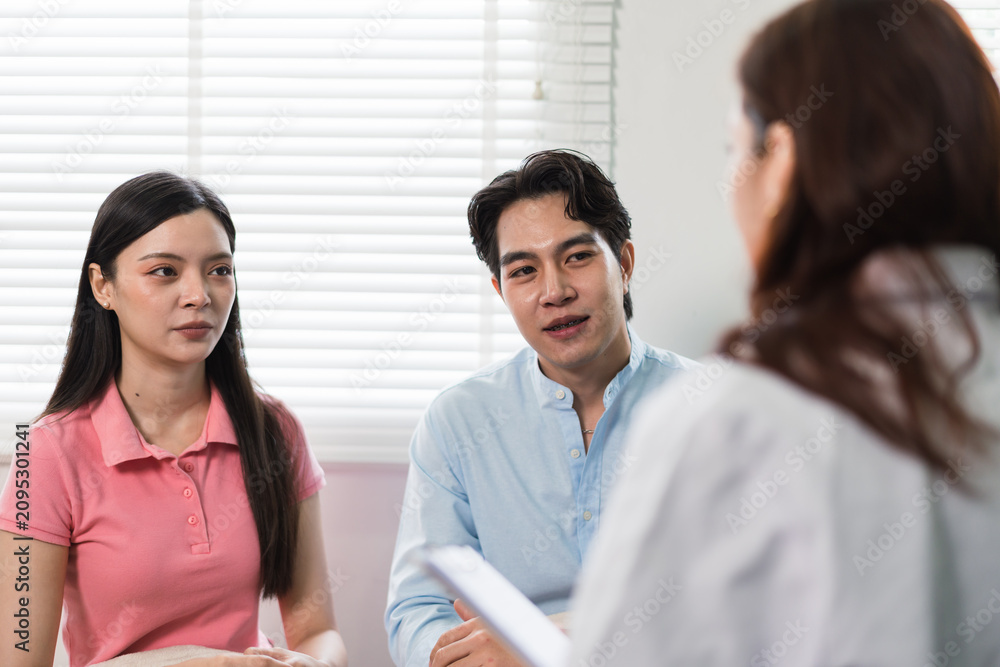 Fototapeta premium Young couple consulting with a healthcare professional during an appointment in a clinical office