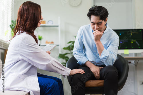 Bild auf Leinwand Female doctor comforting a worried male patient discussing testicular health con