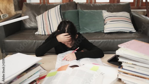 College Asian teenage girl tired and burned out from overwhelmed study pile of books, stressed learning at home with stack of textbooks, reading and writing for school exam, homeschooling education.