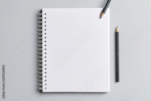 Notebook with spiral binding and pencil on a blank paper notepad for office mockup