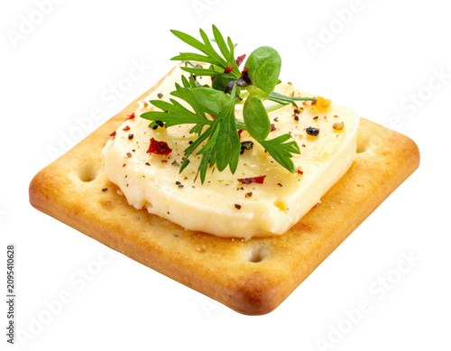 Cracker topped with cheese and fresh herbs