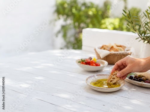 Disfrutar pan con aceite de oliva y verduras en un ambiente al aire libre durante un día soleado