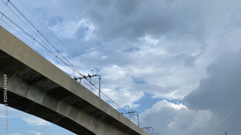 Naklejka premium Elevated concrete metro rail track under a dramatic stormy sky