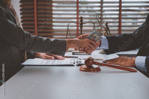 Photos Businessmen shaking hands exchanging money as bribe