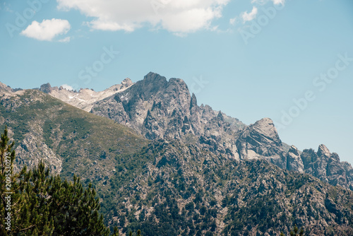 Mineral mountain landscape and steep rocky mountain range under the sky of Corsica
