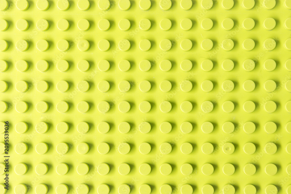 Fototapeta premium Bright Yellowish Green plastic toy construction background. Seamless Lime green building block base plate 