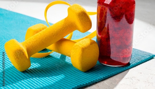 Fitness equipment on a mat with a drink bottle in a gym setting