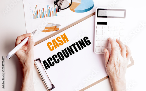 Cash accounting concept with hands using calculator and financial reports representing bookkeeping accounting system cash flow
