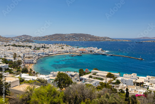 Stunning views of Mykonos island in Greece. Featuring iconic whitewashed architecture, narrow streets, historic windmills, and the sparkling Aegean Sea under a bright summer sky.