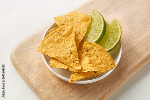 Corn Tortilla chips with slices of lime on a white plate