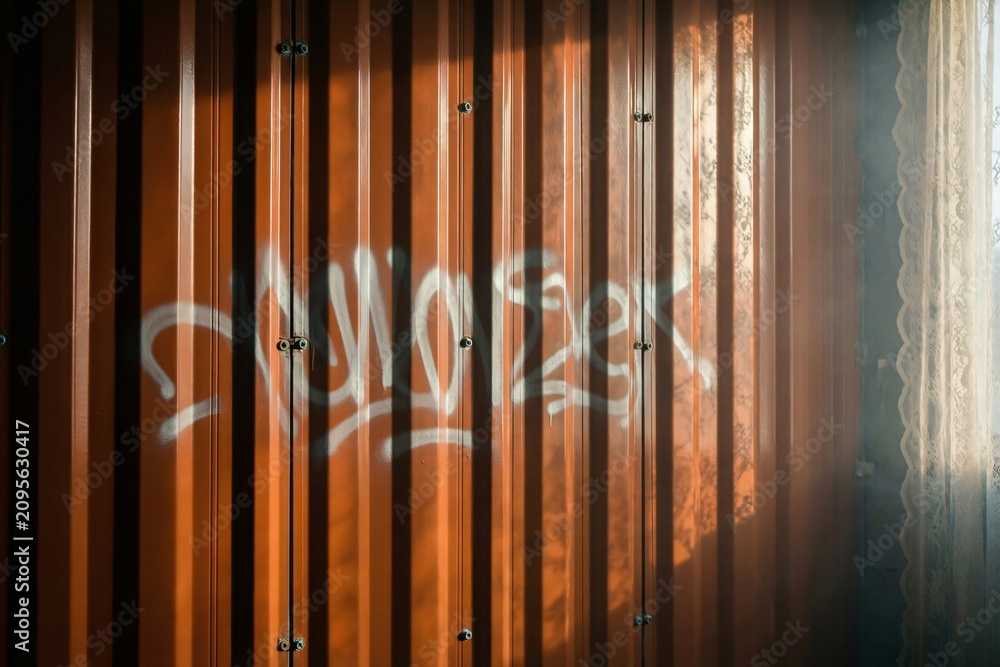 Obraz premium Orange Corrugated Metal Surface with Graffiti and Soft Lace Shadow