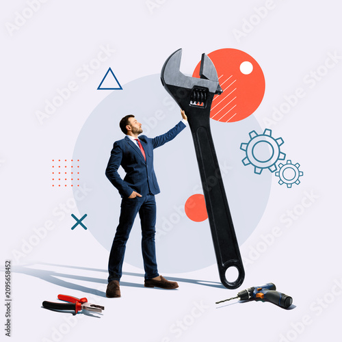 Creative business collage with a businessman interacting with a giant wrench, symbolizing technical expertise, maintenance, problem solving and professional support.