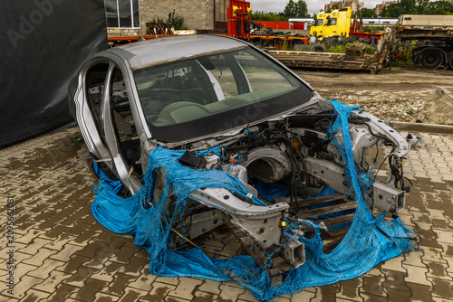 Cuadro en lienzo Abandoned stolen car wreck in a deserted parking lot, bodywork with major components dismantled, engine, gearbox, and seats removed