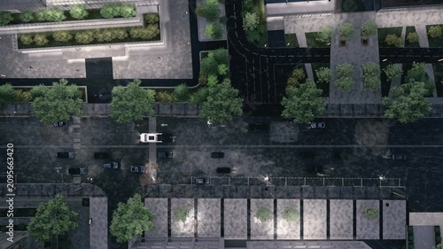 Top Down View of Rainy City Street at Night, 3D Animation of Wet Urban Traffic. Vertical bird eye perspective of a dark boulevard as rain begins to fall. Modern building facades frame the asphalt road
