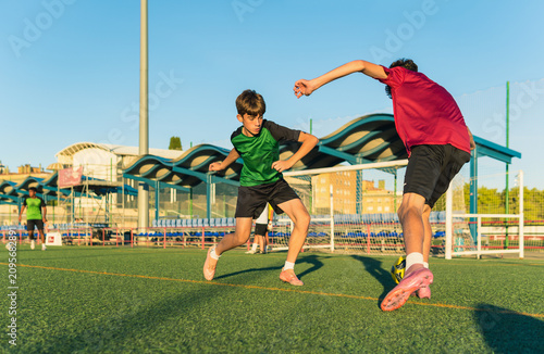 Young boys playing soccer during football training session