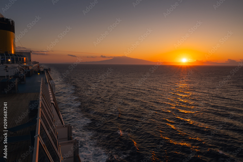 Fototapeta premium Breathtaking view of the active Mount Etna volcano from the sea. A majestic Sicilian landscape featuring the Mediterranean coastline and a towering smoking peak.