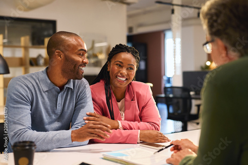 Black mid adult couple meeting financial advisor for investment