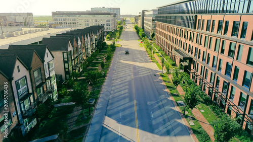 Focused view highlights central roadway connecting diverse building types within master planned development. Consistent structural heights illustrate density management goals in Coppell, TX