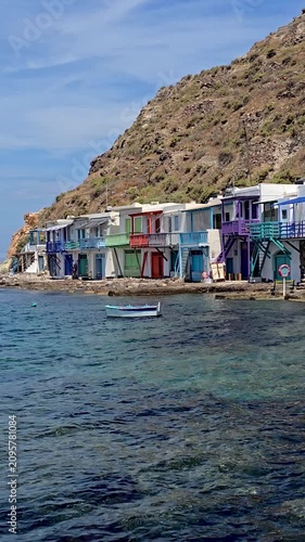 Discover the vibrant colors of traditional fishermen houses along the crystal-clear waters of Milos, Greece. Experience the serene beauty of this picturesque Cycladic island
