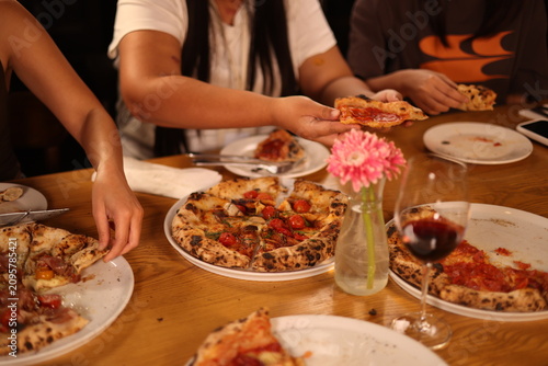 Friends Sharing Gourmet Neapolitan Pizza and Red Wine at Dinner