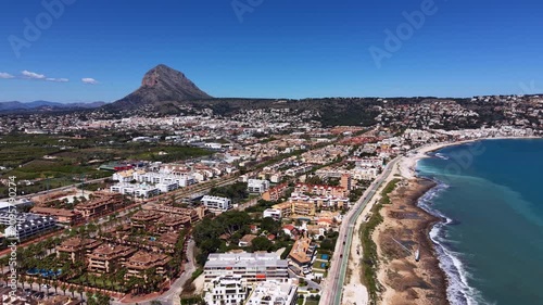 Bird's eye view of Javea (Xabia) coastal town on Costa Blanca showing beachfront promenade, residential buildings and iconic Montgo mountain, Alicante, Spain