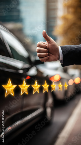 A person is showing a thumbs up gesture while standing next to a black car in a city. Five stars are visible, indicating a positive experience or rating in the late afternoon light.