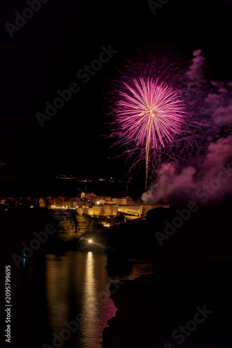 Fireworks exploding over Bonifacio fortified city at night