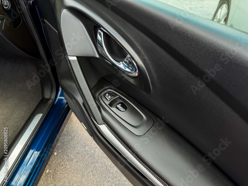 Fotografie Close up of a car door handle and controls showing the interior design of a vehi