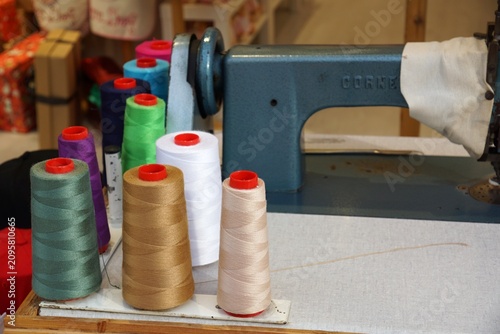 Colorful thread spools near vintage sewing machine in workshop