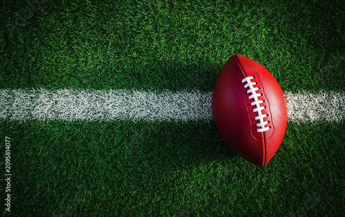 Red Australian Rules football rests on pristine green grass field white line. Sport game object ready for match play. Active recreation outdoors on stadium