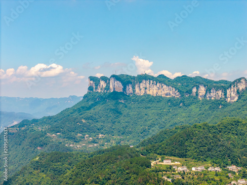 A panoramic view of the lush green mountains and cliffs located near the Three Gorges Reservoir in Yichang China on a bright sunny day