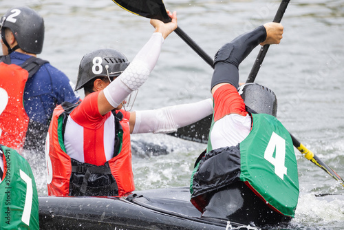 Canvastavla Canoe polo players in colorful jerseys engage in competitive action on a river,