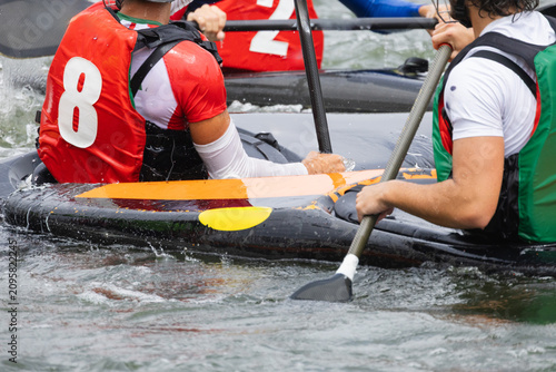 Photography Canoe polo players in colorful jerseys maneuvering their kayaks on a river, show