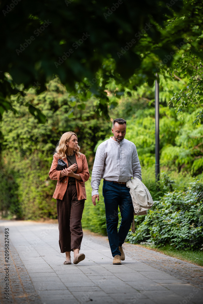 Fototapeta premium Couple walking and discussing in park