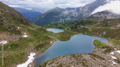 Overhead view of the Tristaina chain of alpine lakes nestled in a rocky green valley in Andorra, with ski slopes and lift infrastructure visible in the background, Pyrenees