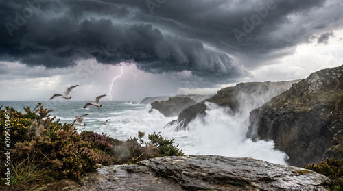 Galerna entrando por la costa con nubes amenazantes, olas gigantes y rayos, capturada desde un espectacular ángulo contrapicado con un realismo cinematográfico impresionante.