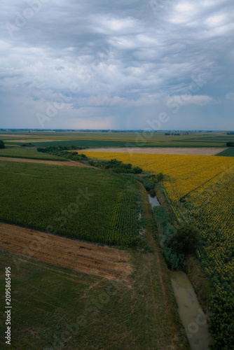 A massive, powerful summer storm looms over vast fields