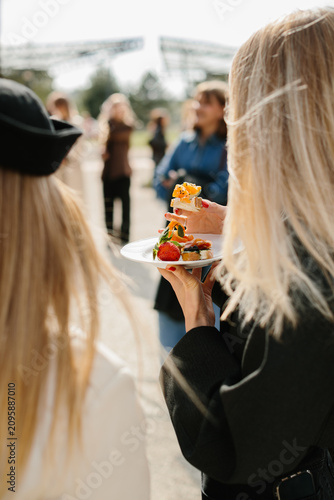 Woman holding catering appetizers at outdoor social event