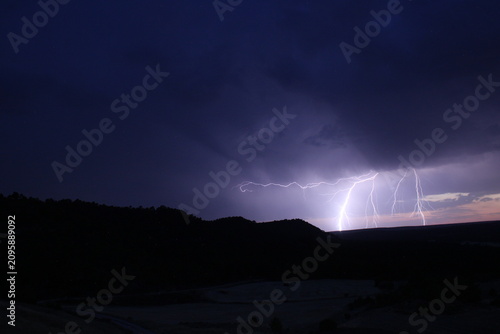 Foto Múltiples rayos de tormenta eléctrica cayendo sobre silueta de montañas