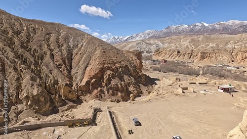 revealing shot Cave window view snow peaks prayer scarves Jhong Chhoser cave Upper Mustang Nepal
