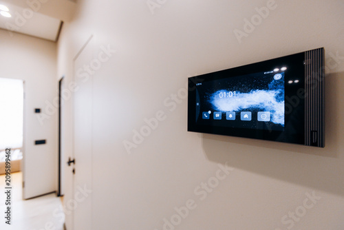 Wall mounted smart home control panel in modern hallway with touchscreen display, ambient lighting, and clean contemporary apartment interior, with smarthome, control, panel, touchscreen detail