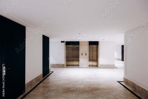 Canvastavla Modern residential elevator lobby with marble flooring and recessed lighting