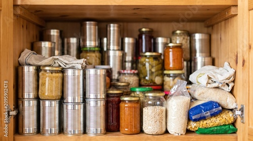 Home Pantry Cupboard Densely Packed With Canned Food and Jars as Stockpiling Metaphor