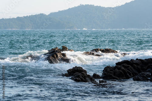 Rocky headlands and rocks are struck by powerful waves that crash with energy. Angra dos Reis – Rio de Janeiro, Brazil.